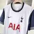 Camisa branca do Tottenham I 24/25, modelo torcedor, com detalhes em azul e logo da Nike.


