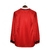 Camisa retrô masculina do Manchester United da temporada 1999/2000, vermelha com detalhes em branco e mangas longas.

