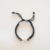 Pulsera tejida con hilo y una cruz
