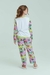 Pijama infantil de manga longa e calça com estampa das Meninas Super Poderosas, apresentado por uma menina sorridente.