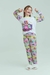 Pijama infantil de manga longa e calça com estampa das Meninas Super Poderosas, apresentado por uma menina sorridente.