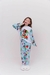 Pijama infantil de manga longa e calça com estampa da Moana, usada por menina sorridente em fundo claro