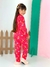 Menina sorridente vestindo pijama básico infantil vermelho com estampas de lua, estrelas e nuvens