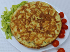 Tortilla de papa grande con cebollita de verdeo