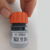 Engate rápido Tramontina com tampa laranja, sendo segurado por uma mão, mostrando a parte inferior com código de referência e código de barras.
