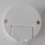 Imagem da parte inferior de uma tomada externa 2P + T de 10 A da marca FLP, mostrando detalhes como a inscrição de segurança e os pontos de fixação.