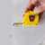 Trena de bolso de 5 metros da marca Starrett, com corpo amarelo e fita visível em milímetros e polegadas.
