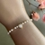 PULSEIRA PEROLAS C/ CORAÇAO NO MEIO