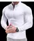 Camiseta esportiva masculina de manga comprida branca, com zíper na gola, destacando o corpo musculoso do modelo.