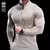 Camiseta esportiva masculina de manga comprida, em tom claro, com zíper frontal e ajuste para atividades físicas.