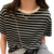 Blusa feminina listrada em preto e branco, com gola clara e acessórios de corrente.