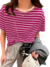 Blusa feminina com listras roxas e brancas, combinada com calças cinzas e acessórios modernos.