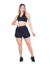 Modelo vestindo saia curta fitness preta e top, exibindo estilo e conforto para atividades físicas.