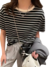 Modelo vestindo uma blusa feminina listrada em preto e branco, combinada com calças confortáveis e acessórios modernos.