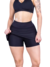 Modelo usando saia curta fitness preta, destacando o design e o conforto para atividades físicas.