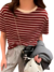 Modelo vestindo blusa feminina listrada em vermelho e branco com calça cinza e acessórios, transmitindo estilo e conforto.