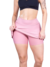 Mulher vestindo saia curta fitness rosa, mostrando o tecido e o design.