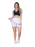 Modelo usando saia curta fitness branca e top preto, mostrando estilo e conforto para atividades físicas.
