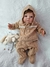 Bebê reborn super realista Miguel vestido com um moletom bege e calças, segurando um coelhinho de pelúcia.