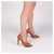 Scarpin Solenne Caramelo com bico fino e salto alto, exibido em uma pose elegante.