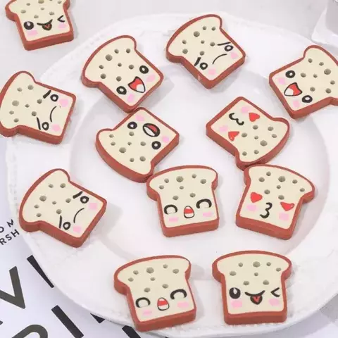 Borracha em formato de fatias de pão com expressões faciais divertidas, dispostas em um prato.