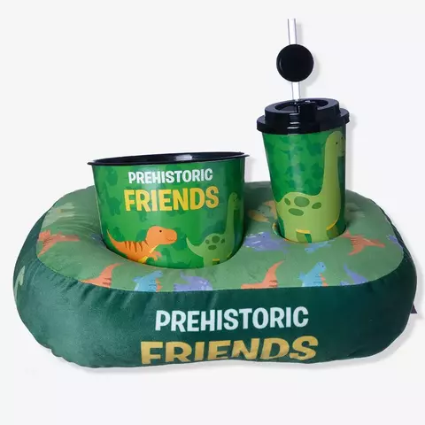 Kit de almofada infantil com tema pré-histórico, incluindo um recipiente para pipoca e copo decorado com dinossauros.