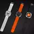 Três smartwatches da Microwear MA27 em diferentes cores: branco, laranja e preto, com mostradores variados.