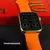 Smartwatch WS25 Mini de 42mm com tela mostrando o recurso de temporizador, acompanhado de uma pulseira laranja e uma caixa vermelha.