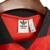 Etiqueta interna da camisa do Flamengo 24/25 da Adidas, na cor vermelha, mostrando detalhes da marca e tamanho.