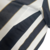 Camisa de torcedor do Santos, predominantemente branca e preta, com listras e detalhes em dourado.