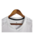Camisa branca do Arsenal 24/25, pendurada em um cabide, com detalhes em preto e logo da Adidas.