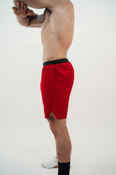 Homem vestindo shorts vermelho V3s Lurk com cós preto, vista lateral, em fundo branco