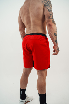 Homem de costas usando shorts vermelhos tijolo da Lurk, com detalhes em preto.