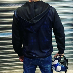 Homem de costas usando um moletom premium preto da marca LK-LIKE, segurando um capacete, em frente a uma parede metálica.