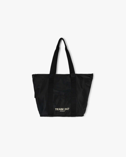 Bolso tote negro Team 247 con asas largas y logo blanco en el frente, ideal para uso diario o gimnasio.