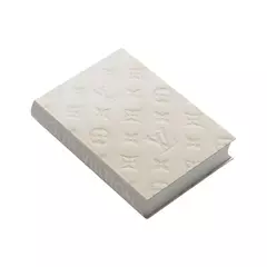 Livro caixa grande da Louis Vuitton com estampa Monograma em um fundo claro.