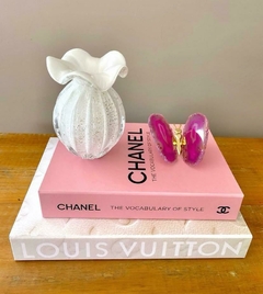 Livro caixa grande da Louis Vuitton com estampa Monograma em um fundo claro com murano e borboleta de ágata rosa
