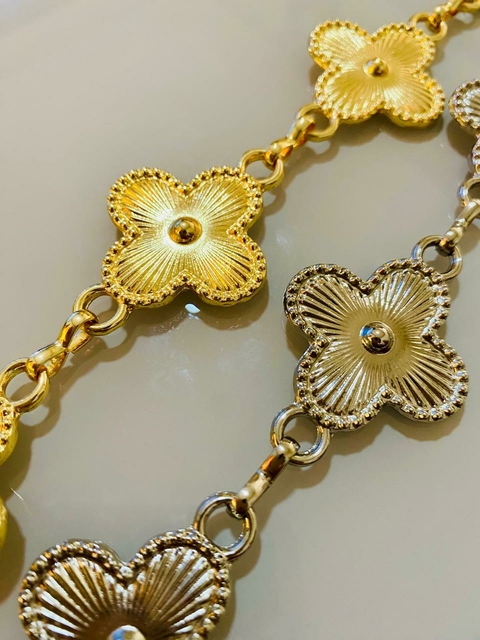 Cinto decorado com detalhes em forma de flores douradas, exibindo um design elegante.