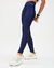 Calça legging trilobal azul eclipse, destacando a modelagem e o brilho do tecido, usada por uma mulher em ambiente neutro.
