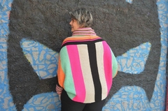 Blusa morcego listrada colorida com comprimento maior na parte de trás, gola alta e mangas longas.