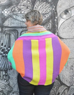 Blusa morcego listrada colorida com comprimento maior na parte de trás, gola alta e mangas longas.