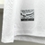 Detalhe da etiqueta da camisa branca do Santos Futebol Clube, destacando o Estádio Urbano Caldeira e a frase "A vila mais famosa do mundo".