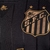 Detalhe do escudo do Santos na camisa Charlie Brown JR. Legacy Unisex, com listras pretas e douradas.