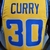 Camiseta regata amarela e azul do Golden State Warriors, com o nome "CURRY" e o número "30" na parte de trás.