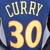 Camiseta regata azul e laranja do Golden State Warriors com o nome "Curry" e o número 30.