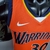 Camiseta regata laranja do Golden State Warriors, marca Nike, com detalhes em azul e amarelo.