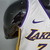 Camiseta regata branca dos Los Angeles Lakers, marca Nike, vista em um manequim. Detalhes em amarelo e roxo.