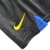 Detalhe do kit infantil Inter de Milão I 23/24 da Nike, mostrando a logo amarela e a parte azul da camisa.