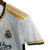 Camisa do Kit Infantil do Real Madrid, modelo 23/24, na cor branca com detalhes em azul e amarelo.