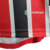 Detalhe do Kit Infantil São Paulo Away 23/24 da Adidas, destacando as cores vermelho e preto com o logo Aeroready.